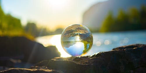 A clear marble reflecting the landscape such that it looks like a globe