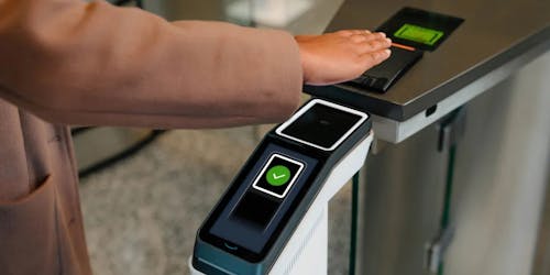 A customer holds their hand over an Amazon One scanner that uses a scan of their palm to process payment