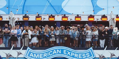 Concert goers standing on an American Express seating area 