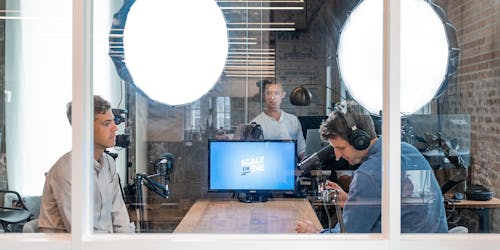 office workers, recording a podcast in closed off room