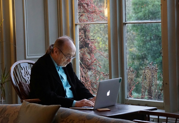 An older man at a laptop