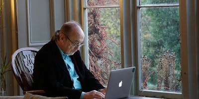 An older man at a laptop