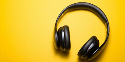 A pair of headphones on a yellow background