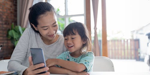 Child with mother looking at phone