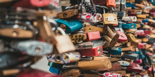 Numerous colorful padlocks attached to a surface