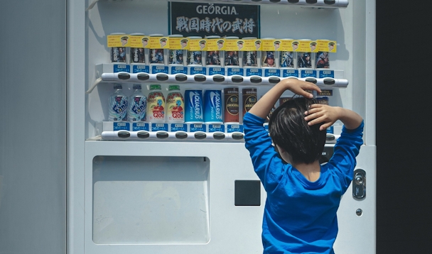 A child looks at drinks in a vending machine