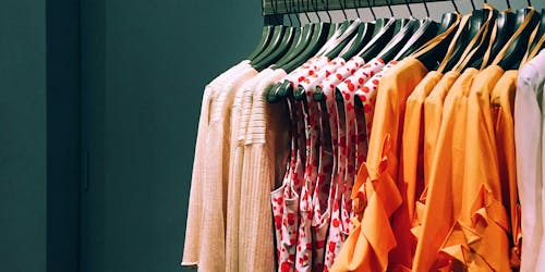 Red and orange clothes on a clothing rail