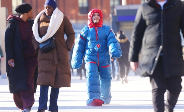 Man walking down the street in a Domino's heatsuit 