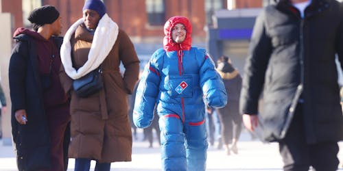 Man walking down the street in a Domino's heatsuit 