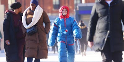 Man walking down the street in a Domino's heatsuit 