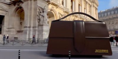 A brown Jacquemus handbag travels through the streets of Paris in a still from an augmented advert