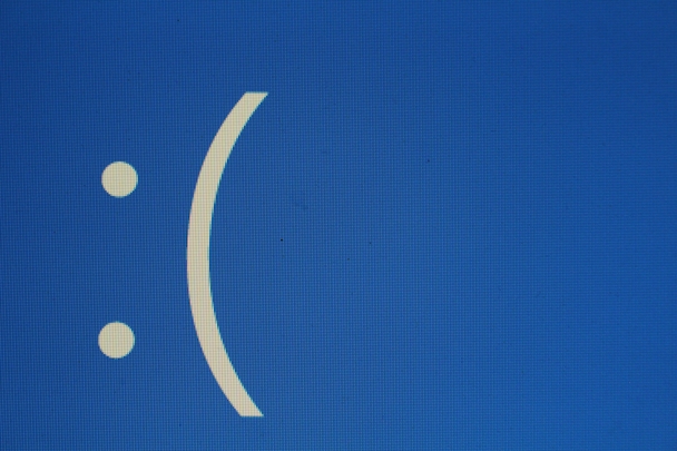 Blue screen showing a computer crash with a sad emoji