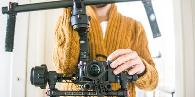 A man stands behind a camera rig