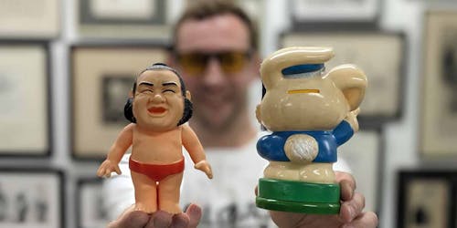 Lee Bofkin holds up two plastic mascots he bought on a recent trip to Japan