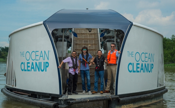 People standing on a boat that says Ocean Clean Up 