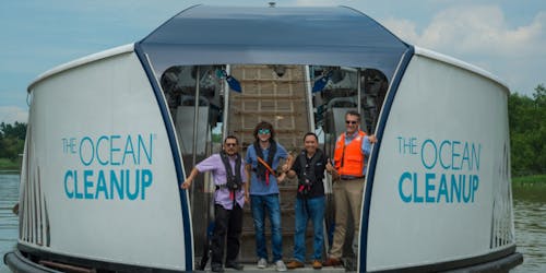 People standing on a boat that says Ocean Clean Up 