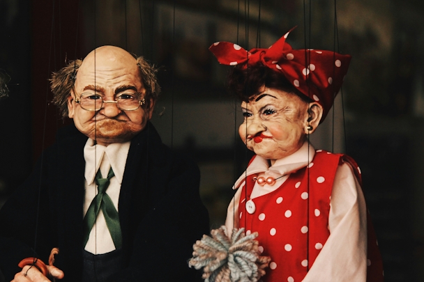 Two puppets, of an older man and an older woman