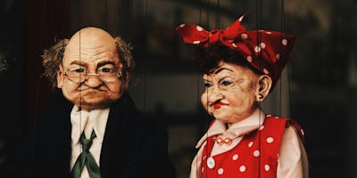 Two puppets, of an older man and an older woman