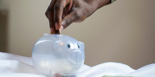 Piggy bank with someone putting money in it