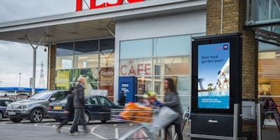 A Tesco store with an out of home advertisement outside