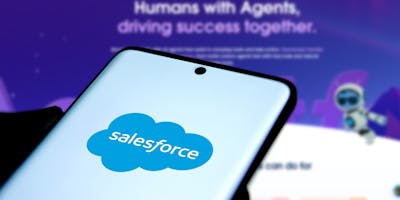 Salesforce logo on mobile phone screen in front of Agentforce landing page in the background