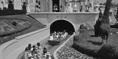 people on the small world ride in black and white