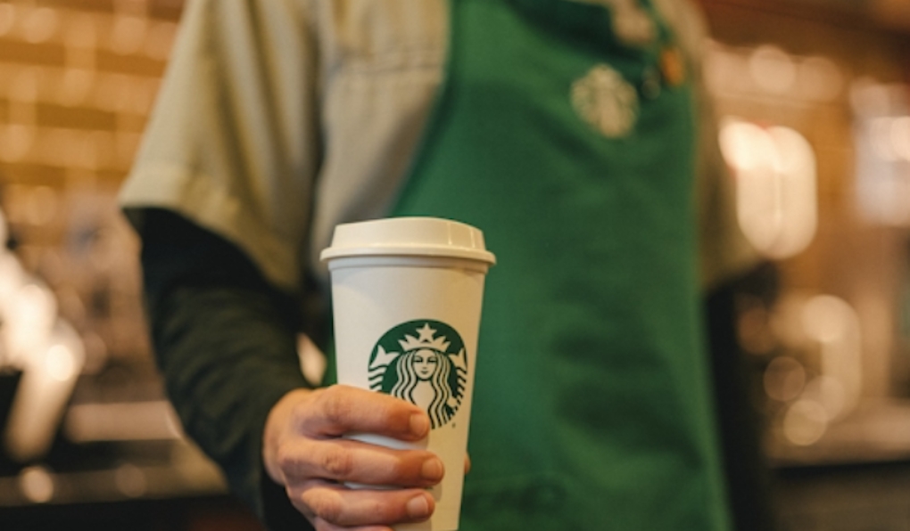 Starbucks coffee cup being held by a barista 