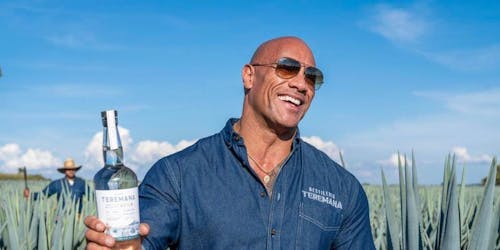 Dwayne "The Rock" Johnson holds a bottle of his tequila