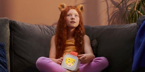 Girl holding a Yoto device with bear ears on her 